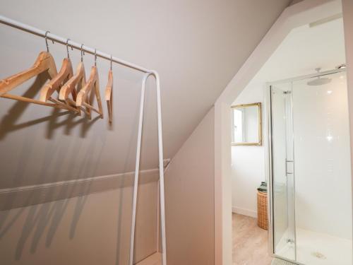 a walk in closet with wooden hangers and a mirror at Peppermill Cottage in Banff