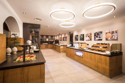 a restaurant with a food counter in a room at Landhotel Schermer in Westendorf
