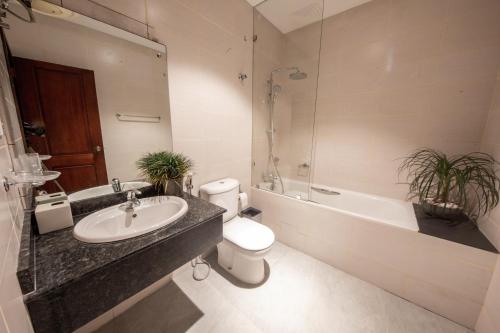 a bathroom with a sink and a toilet and a bath tub at Anaya Living - Colombo 03 in Colombo