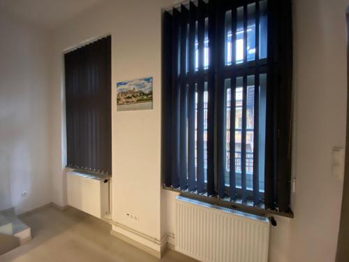 a room with two windows with black blinds at Hunyady Gallery Apartment in Budapest