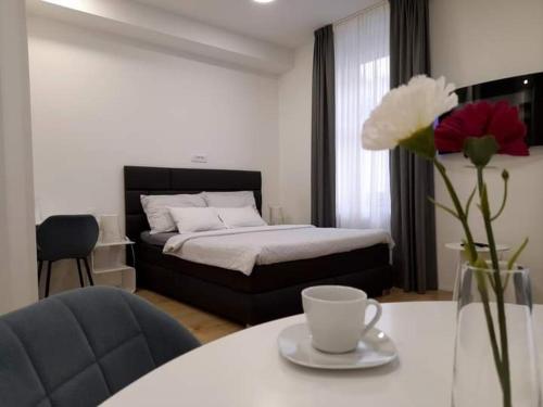 sypialnia z łóżkiem i stołem z wazonem kwiatów w obiekcie City Center Main Square Apartments Zagreb w Zagrzebiu