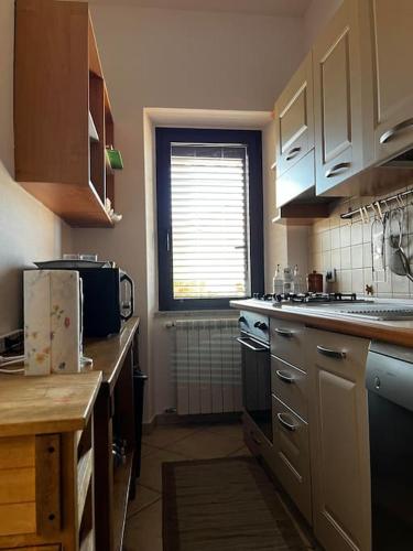 a kitchen with white cabinets and a window at Sardegna: mare e montagna IUN R0346 in Oliena