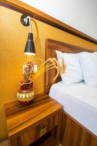 a lamp on a night stand next to a bed at Mai Danube in Eşelniţa