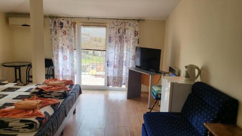 uma sala de estar com duas camas e uma janela em Къща за гости Алекс em Sinemorets