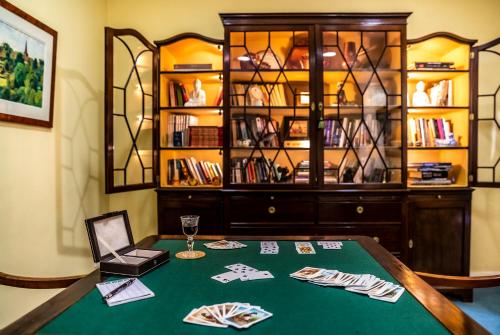 a poker table with a chair and a book shelf at Grande Hotel das Caldas da Felgueira in Caldas da Felgueira