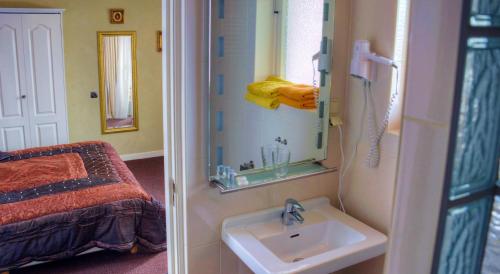a bathroom with a sink and a bed and a mirror at Pension & Spa de Watertoren in Zandvoort
