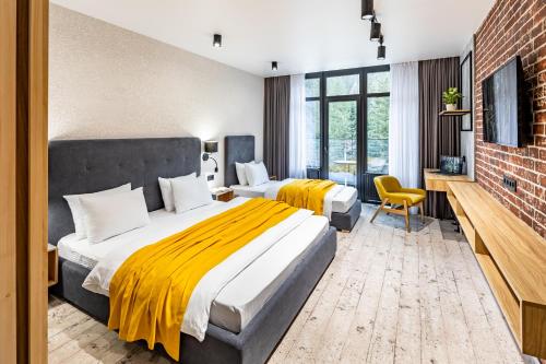 two beds in a room with a brick wall at Wood Hotel Resort & SPA in Bukovel