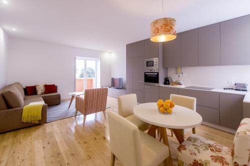 a kitchen and a living room with a table and chairs at Tea 4 Nine Guest House in Braga