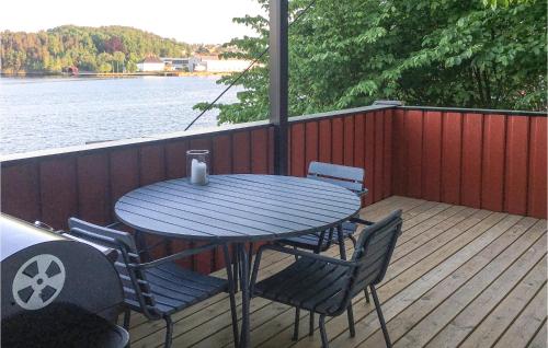 a table and chairs on a deck next to the water at Stunning Apartment In Arendal With Wifi in Arendal