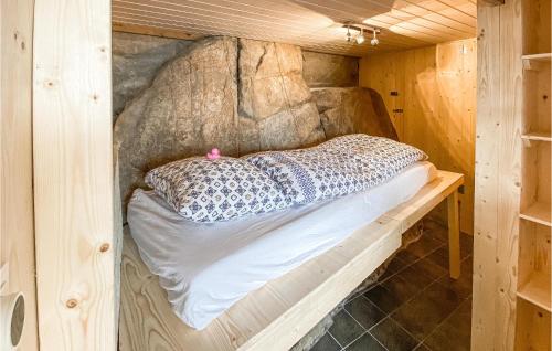 a bed in a wooden cabin with a wall at Stunning Apartment In Arendal With Kitchen in Arendal