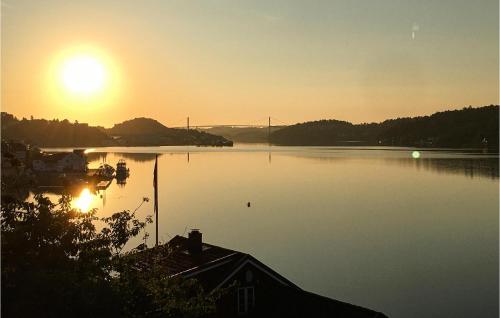 a sunset on a lake with a bridge in the background at Stunning Apartment In Arendal With Wifi in Arendal