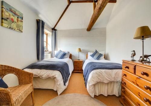 a bedroom with two beds and a dresser at Lilac Barn in Swanton Abbot