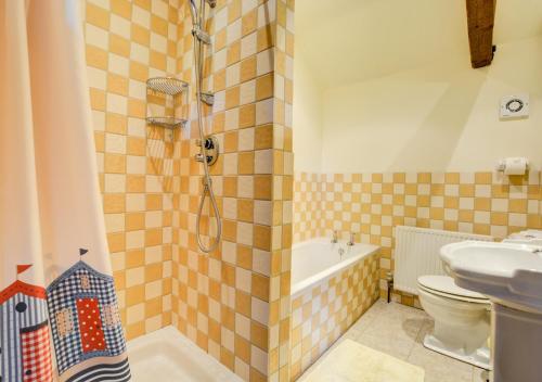 a bathroom with a shower and a toilet and a sink at Lilac Barn in Swanton Abbot