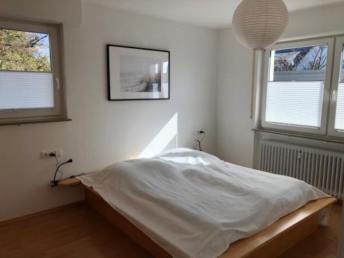 a bedroom with a white bed with two windows at Appartement Stuttgart Messe & Flughafen in Leinfelden-Echterdingen