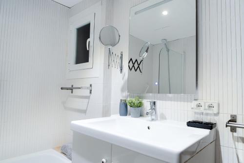 a white bathroom with a sink and a mirror at Veronica Beachfront Apartment by FESEAL in Port de Pollensa