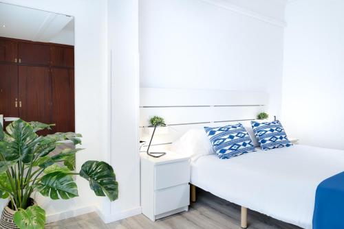 een slaapkamer met een bed met blauwe en witte kussens bij Apartment Veronica-Puerto Pollensa in Port de Pollença