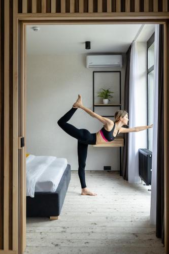 a woman doing a yoga pose on a bed at Wood Hotel Resort & SPA in Bukovel
