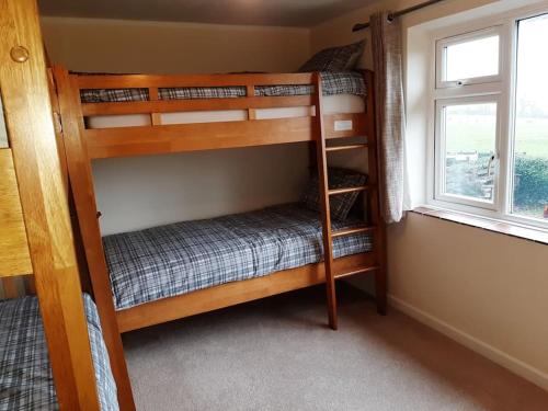 two bunk beds in a room with a window at Countryside Home Snowdon & Snowdonia National Park in Llanrug
