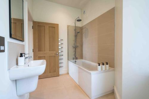W łazience znajduje się umywalka i wanna. w obiekcie Beautiful Beach side Apartment w mieście Torquay