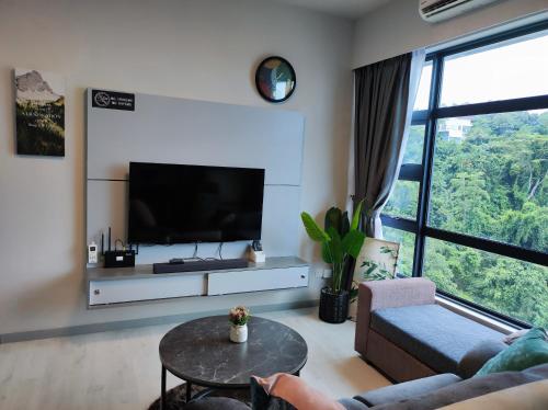 a living room with a tv and a couch and a table at SabahSuite@Jesselton Quay in Kota Kinabalu