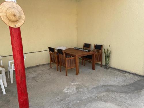 ein Zimmer mit einem Holztisch mit Stühlen und einem Sonnenschirm in der Unterkunft AmarCasa in Nora