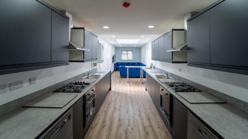 a large kitchen with stainless steel appliances and wooden floors at FREE PARKING Cosy Studios close to city and QE and UOB! in Birmingham