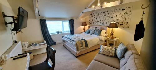 a small bedroom with a bed and a couch at Salmon Landings in Strathy Point