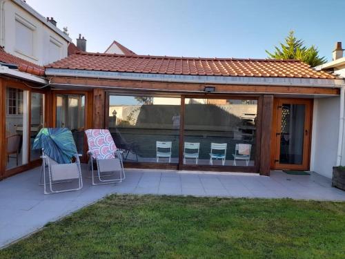 a screened in patio with chairs and a table at Gite Troubadour - Cap Gris Nez - piscine in Audinghen