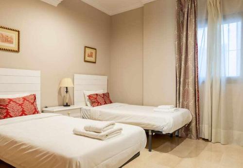 1 dormitorio con 2 camas y ventana en Obispo Apartamento junto a la Catedral de Málaga en Málaga