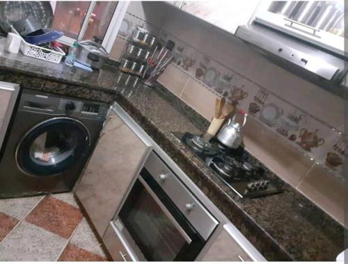 a kitchen with a stove and a washing machine at Apartment bien equipee acasa in Casablanca