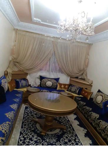 een woonkamer met een tafel en een kroonluchter bij Apartment bien equipee acasa in Casablanca