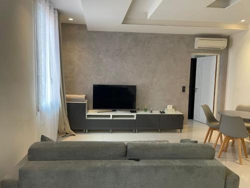 a living room with a couch and a flat screen tv at Cap d ail 2 pièces proches Monaco et plage in Saint-Antoine