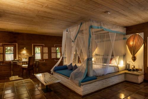 um quarto com uma cama de dossel em Ayurvie Sigiriya - Ayurvedic Retreat by Thema Collection em Sigiriya