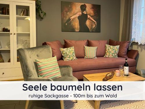 a living room with a brown couch and a table at Der Fuchsbau - Fewo LePetit - im sonnigen Harz - Hunde willkommen - 100m bis zum Wald - FREE WLAN in Bad Sachsa