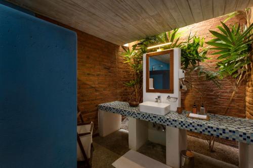 ein Bad mit einem Waschbecken und einem Spiegel in der Unterkunft Ayurvie Sigiriya - Ayurvedic Retreat by Thema Collection in Sigiriya