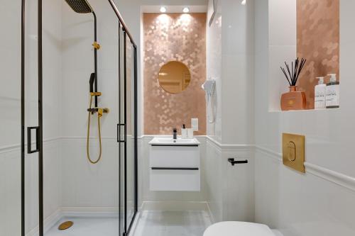 a bathroom with a shower and a toilet and a sink at Downtown Apartments Riverside Nadmotławie - Parking, Sauna & Gym in Gdańsk