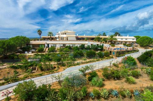 an aerial view of a building with a road in front at Monte da Bravura Green Resort in Bensafrim