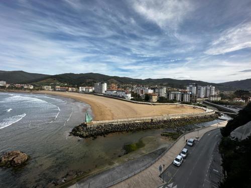 a beach with cars parked next to the water at Bakio, magnificas vistas a la mar in Bakio