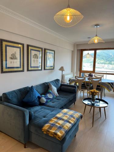 a living room with a blue couch and a table at Bakio, magnificas vistas a la mar in Bakio