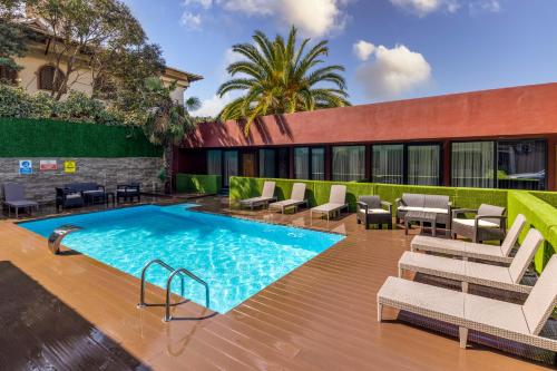 a swimming pool with lounge chairs and a building at BayMari Suites Plus Florya in Istanbul