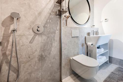 a bathroom with a shower and a toilet and a mirror at The Grand Apartment Rovinj in Rovinj