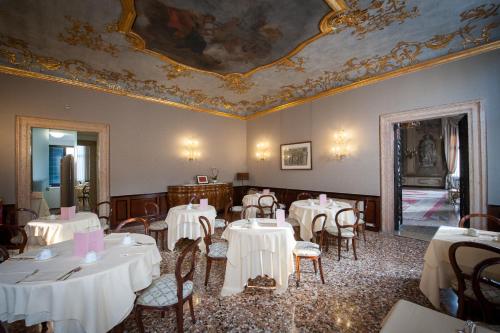a restaurant with white tables and chairs and a ceiling at Ca' Sagredo Hotel in Venice