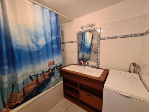 une salle de bain avec un lavabo et un rideau de douche dans l'établissement Maison lumineuse avec piscine, à 2 pas de l'océan - 5 couchages, Saint-Jean-de-Monts - FR-1-224C-125, à Saint-Jean-de-Monts