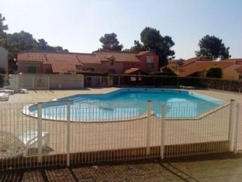 une clôture autour d'une piscine dans une cour dans l'établissement Maison lumineuse avec piscine, à 2 pas de l'océan - 5 couchages, Saint-Jean-de-Monts - FR-1-224C-125, à Saint-Jean-de-Monts