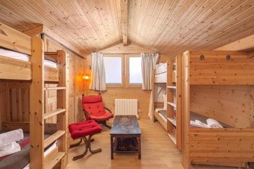 a room with bunk beds and a table and a chair at Chalet Gentil Family friendly Mountain getaway in Riddes
