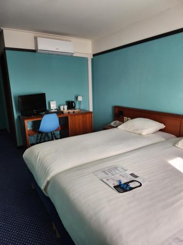 um quarto de hotel com uma cama com um jornal em Hotel Royal Zelzate em Zelzate