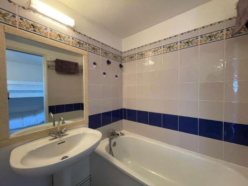 La salle de bains est pourvue d'un lavabo, d'une baignoire et d'un miroir. dans l'établissement Maison Saint-Jean-de-Monts, 1 pièce, 5 personnes - FR-1-224C-190, à Saint-Jean-de-Monts