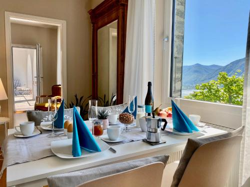 a table with blue napkins on it with a window at Casa Sonora in Orselina