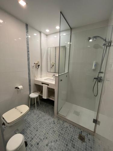 a bathroom with a shower and a toilet and a sink at Hotel Albatros in Gandía