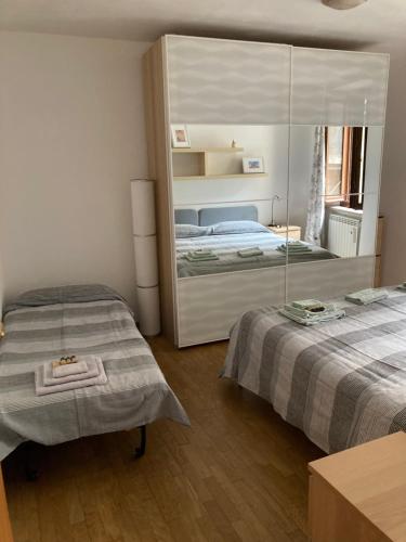a bedroom with two beds and a large mirror at Casa Vacanze Mary in Orvieto